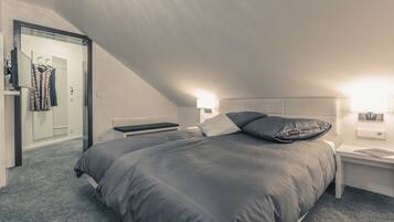 Un dormitorio con una cama grande, una mesita de noche y un espejo.