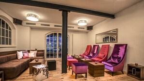 Un intérieur moderne avec un plancher en bois, un canapé en cuir et des fauteuils violets.