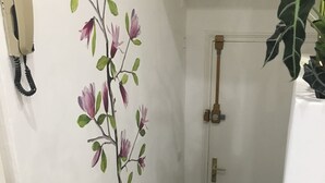 Una escalera con escalones de madera, un teléfono sujeto a la pared y una puerta con manija de latón.