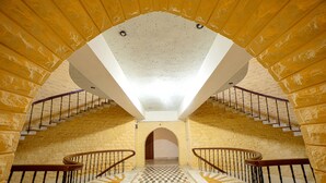 Una escalera con piso a cuadros y techo abovedado.