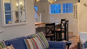 Ein modernes Wohnzimmer mit einem blauen Sofa, einem Essbereich und einem Oberlicht.