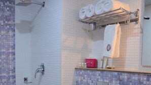 A bathroom with a shower, toilet, and sink. - JAI MAATA GRANDEUR (Shimoga)