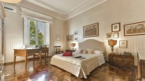 Ein Schlafzimmer mit einem großen Bett, einem Schreibtisch und einem Fenster.