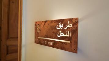 A sign with Arabic text on a wall.