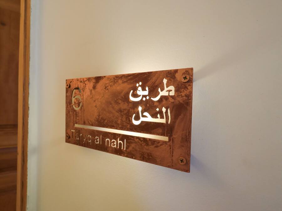 A sign with Arabic text on a wall.