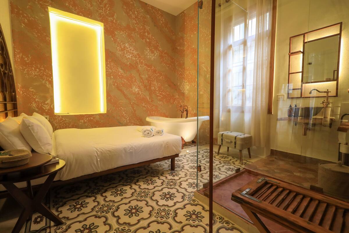 Un baño moderno con bañera, cabina de ducha de vidrio y un espejo grande.