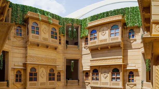 Un patio con arquitectura ornamentada, varios balcones y zonas de estar.