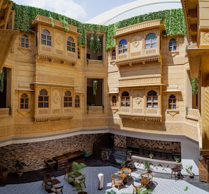 A courtyard with ornate architecture, multiple balconies, and seating areas.