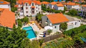 Un quartiere residenziale con diversi edifici, una piscina e montagne sullo sfondo.