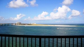 Vista costera con un puente, playa y océano.