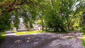 A gravel driveway leading to a residential area with houses and trees. - Cozy & Quiet Studio Flat in Historic Mount Clemens (Mount Clemens)