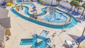 A pool area with multiple swimming pools, lounge chairs, and sun umbrellas. - Updated Ocean View 2BR|2BA Condo (Myrtle Beach)