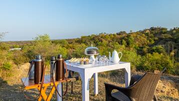 A picnic setup with a table, chairs, and outdoor dining accessories.