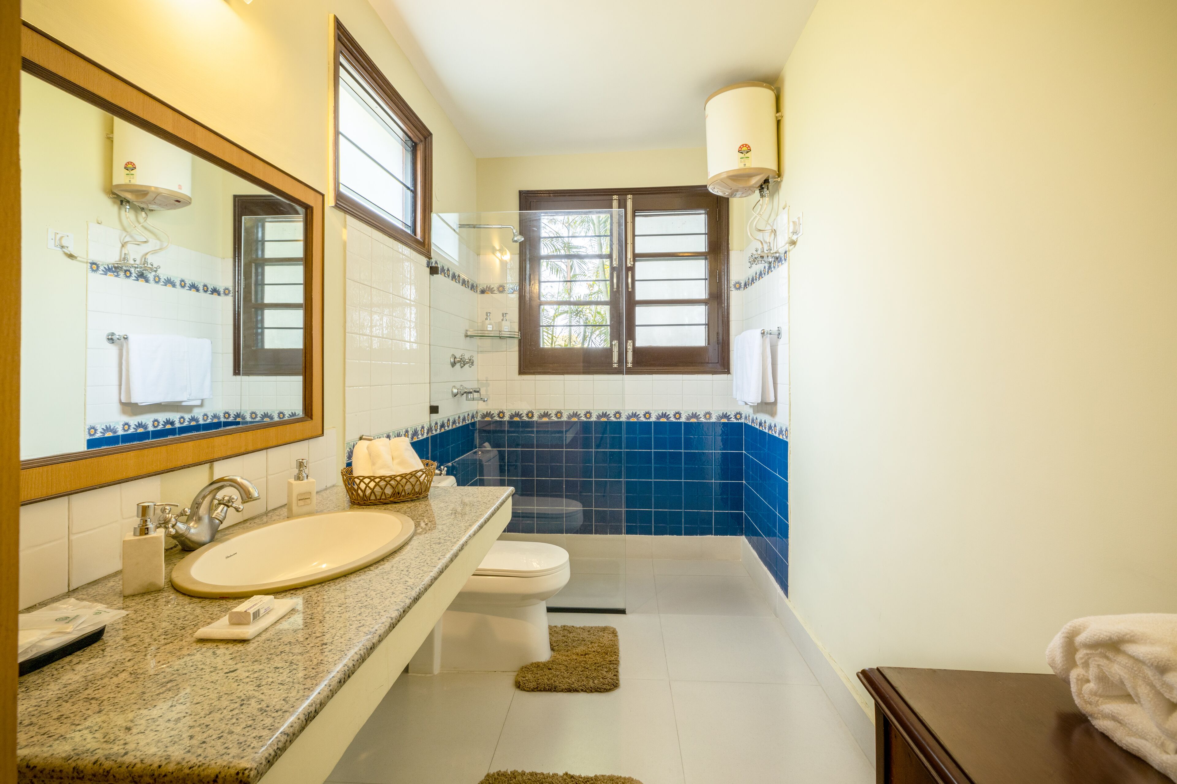 A bathroom with a sink, toilet, and mirror.