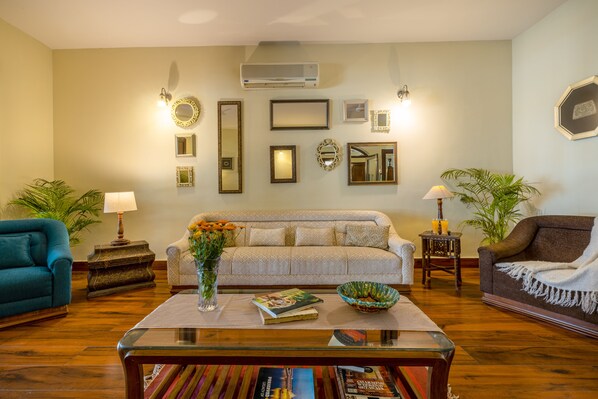 A living room with a sofa, armchairs, a coffee table, and various decorative items.