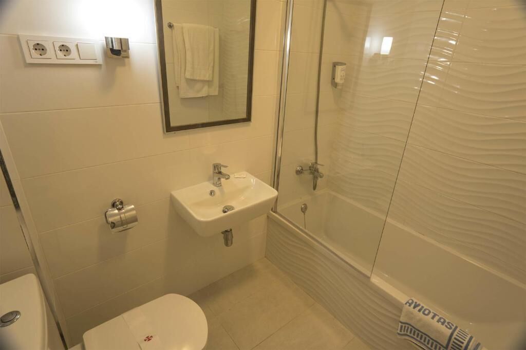 A bathroom with a sink, toilet, and glass-enclosed shower.