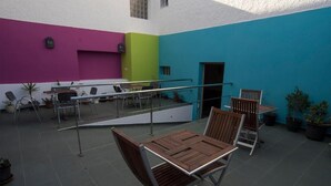 An outdoor patio with a table and chairs, a railing, and potted plants. - Hostal Las Gaviotas del Cabo (Nijar)