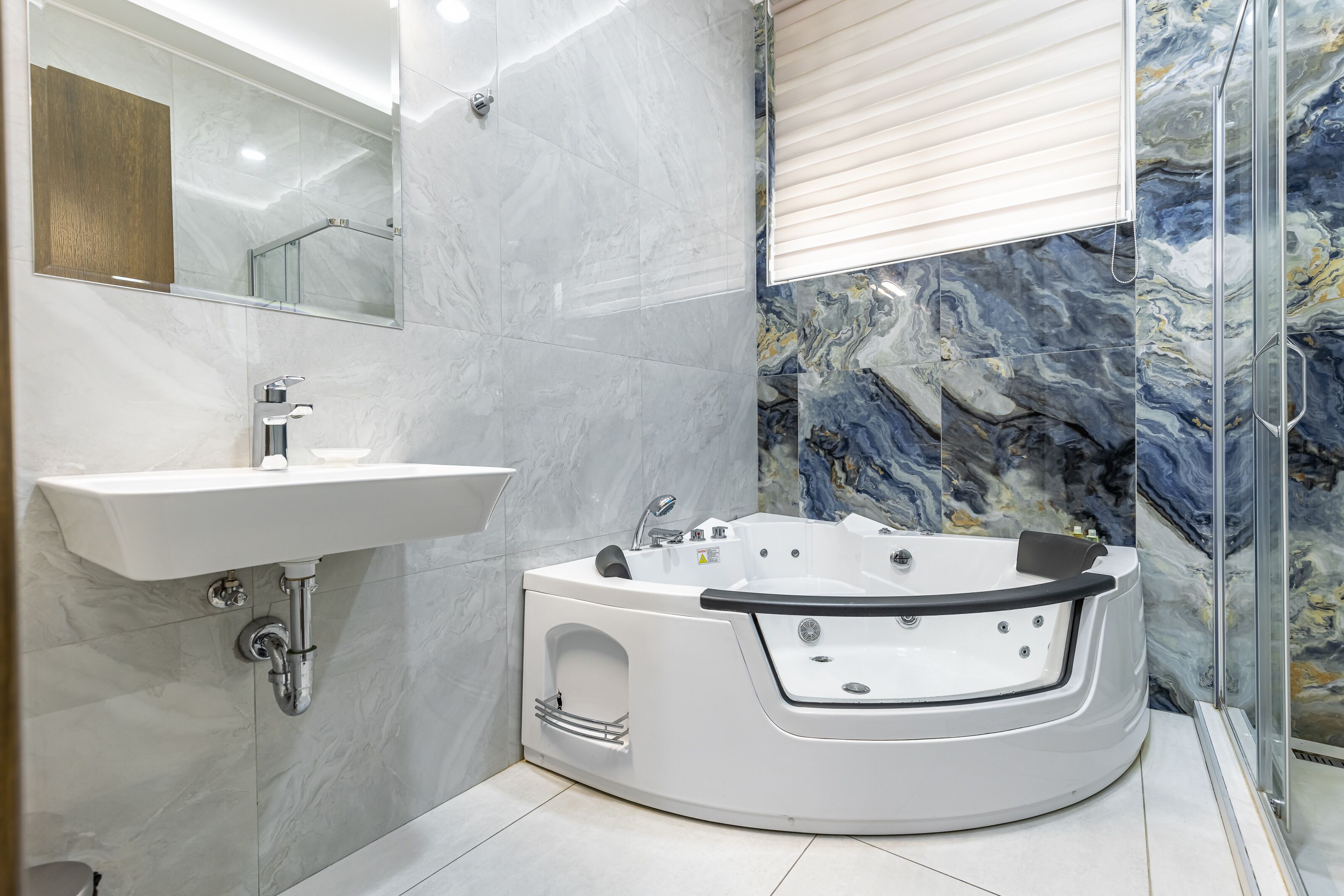 A modern bathroom with a white bathtub, a sink, and a glass shower enclosure.