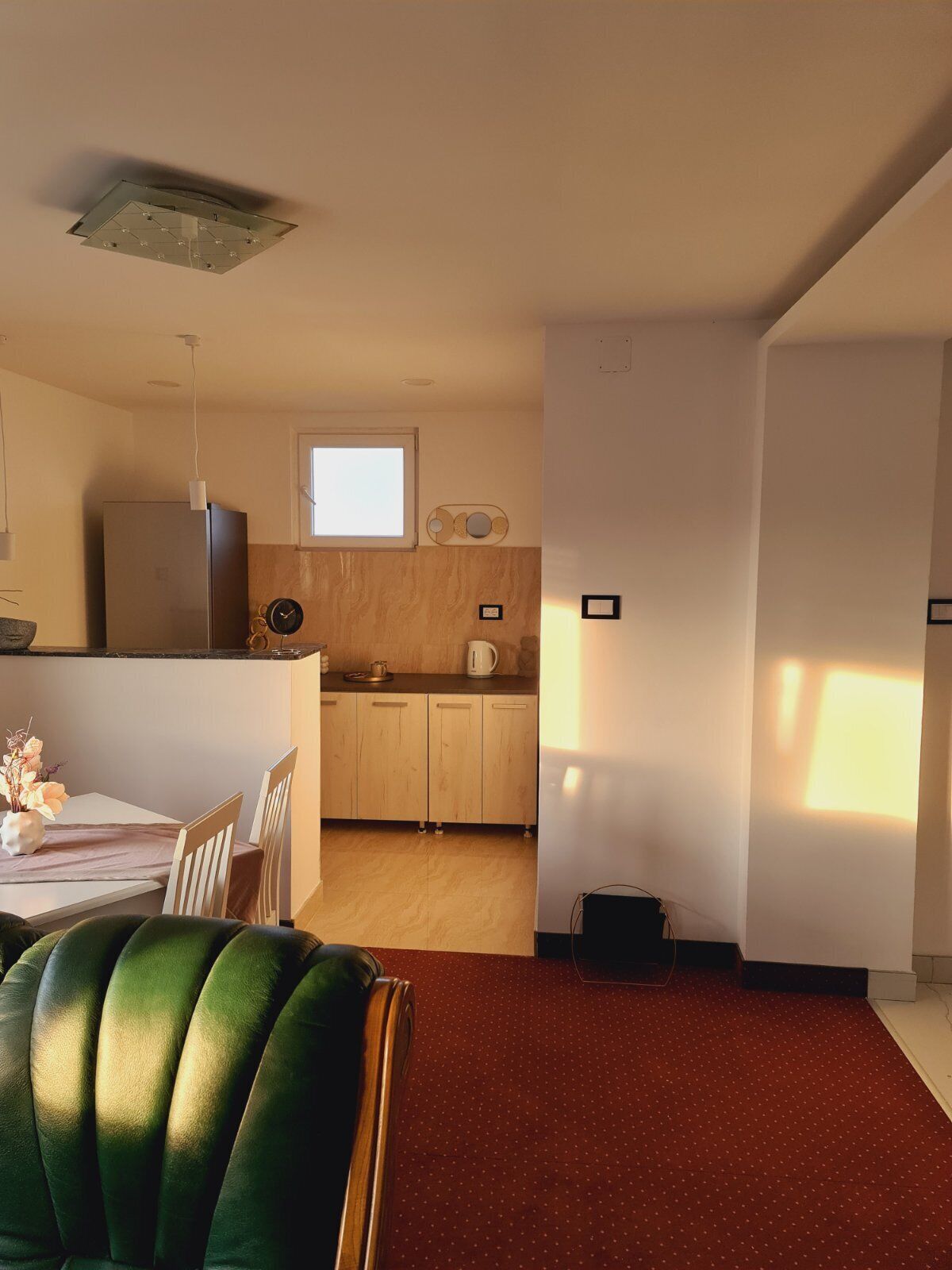 A compact kitchen with wooden cabinets, a built-in oven, and a window above the sink.