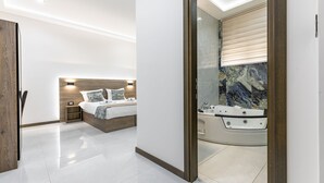 Un dormitorio moderno con una cama grande, mesitas de noche y una bañera integrada.