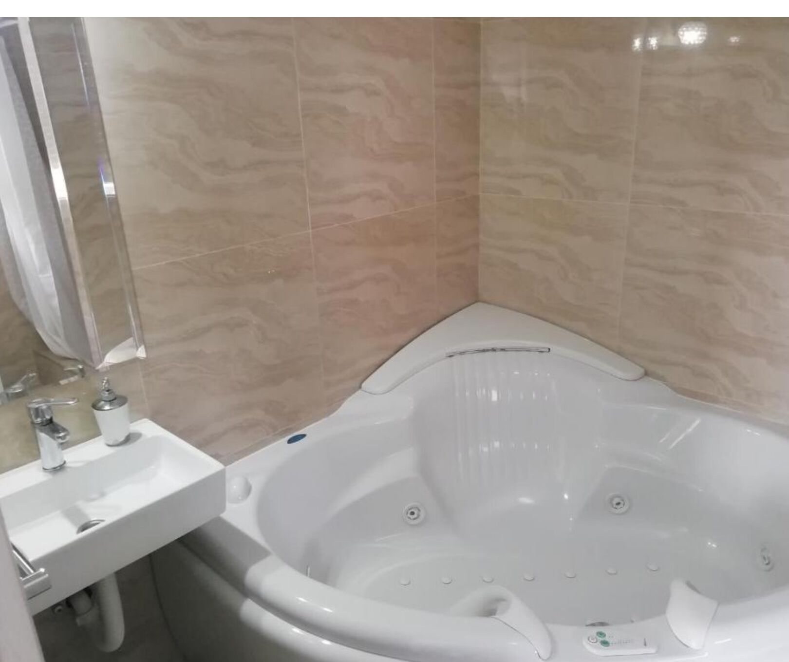 A bathroom with a white bathtub, a sink, and a mirror.