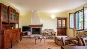 Una sala de estar con chimenea, muebles de madera y una televisión.