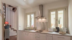 A modern kitchen with a stainless steel range hood, a built-in sink, and a toaster. - Roof Cathedral Sevilla (Sevilla)