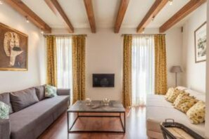 A living room with a sofa, a coffee table, and curtains. - Roof Cathedral Sevilla (Sevilla)