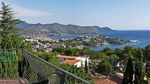 A balcony with a view of a coastal town, mountains in the distance, and a clear blue sky. - Apartment Cathy by Interhome (Llançà)