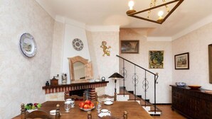 A dining area with a wooden table, chairs, and a chandelier. There is a staircase with a railing leading to another level. - Apartment Cathy by Interhome (Llançà)