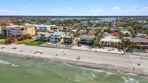 Une ville côtière avec une plage, des bâtiments et un ciel dégagé.