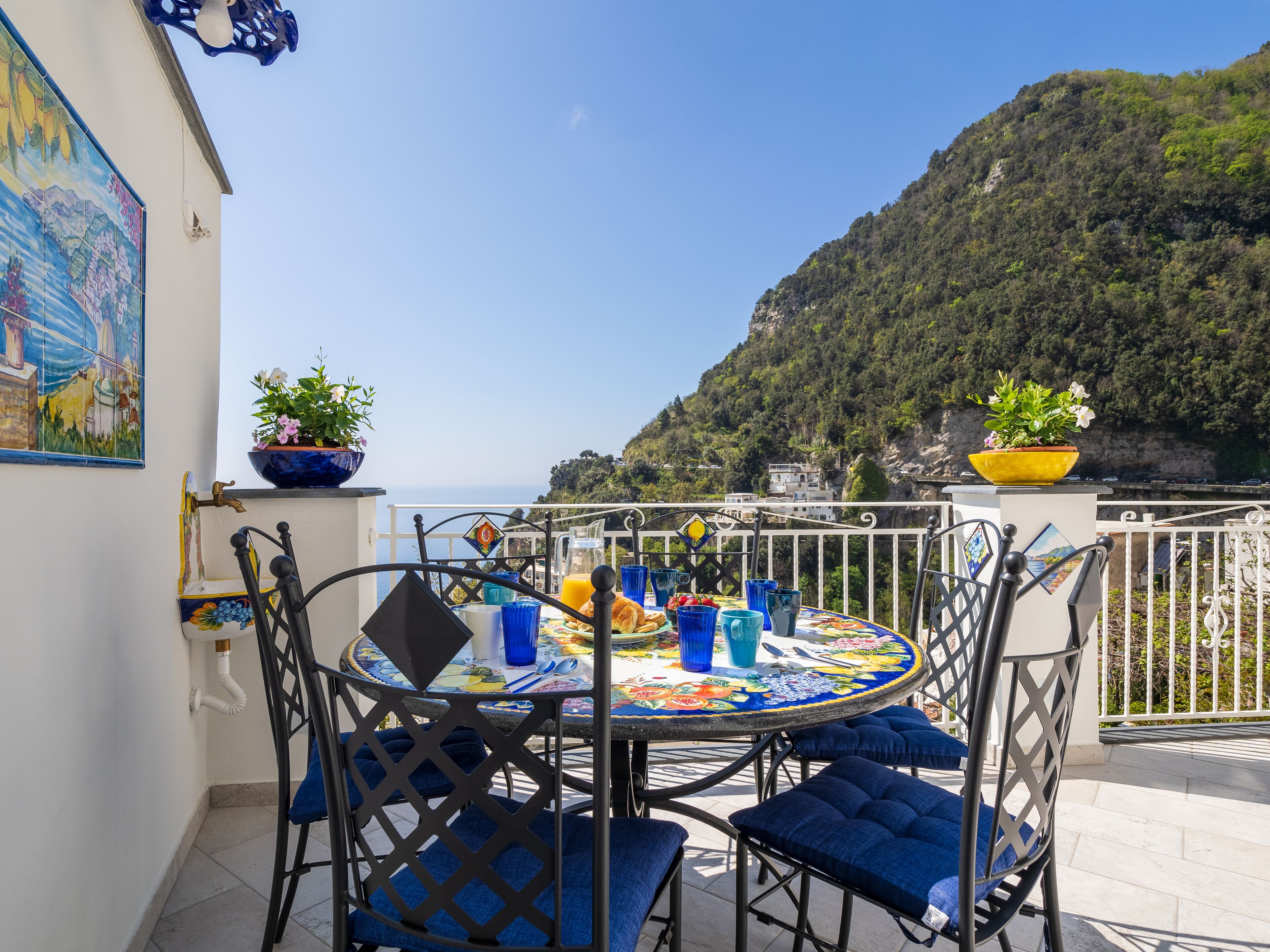 Un tavolo rotondo con sedie e vista sul mare.
