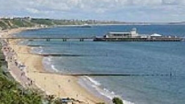 A coastal scene with a beach, a pier, and a distant shoreline. - Ingledene Guest House  (Bournemouth)