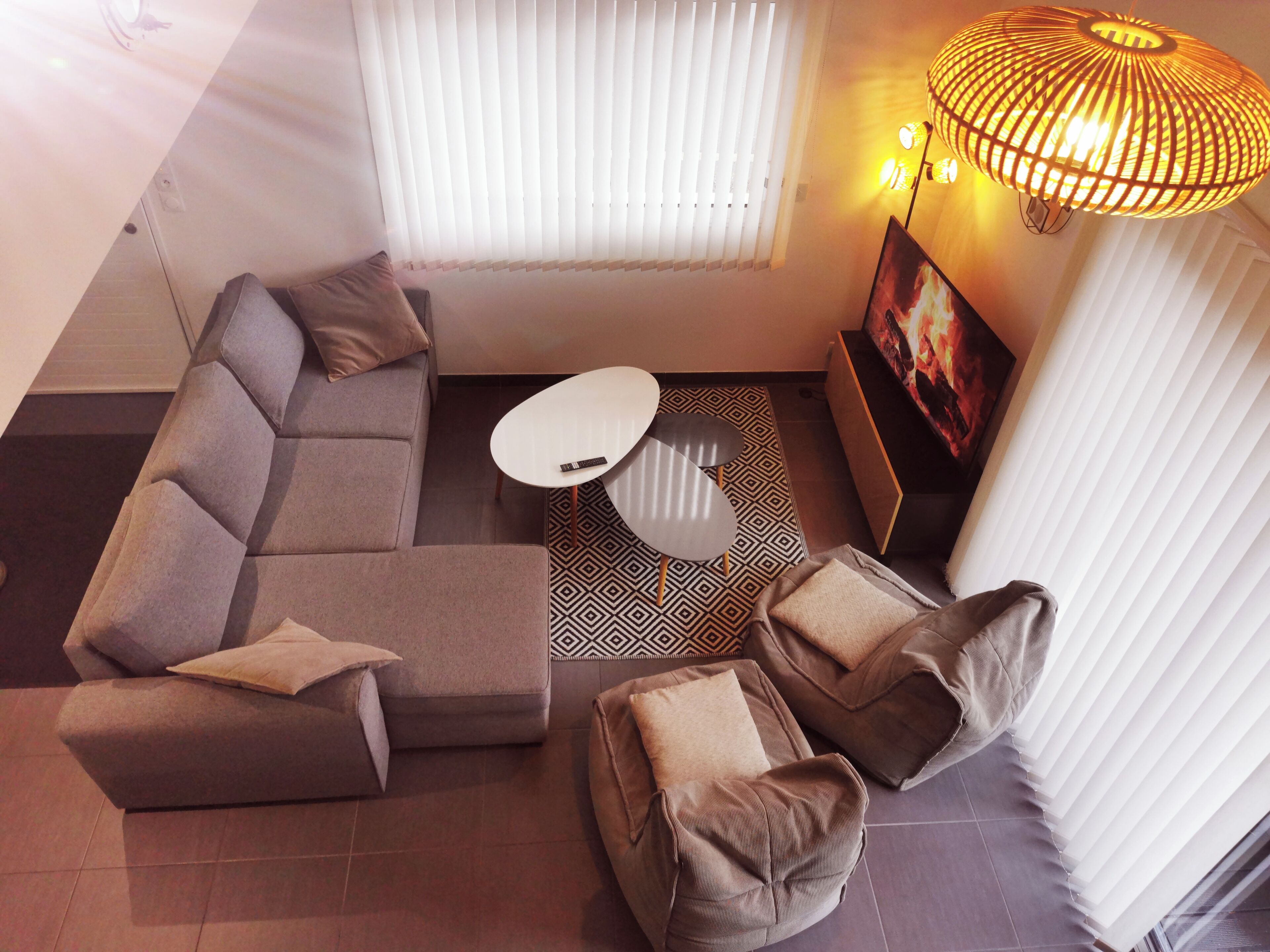 A modern living room with a sectional sofa, a small round table, and a patterned rug.