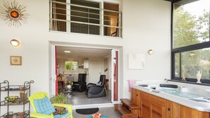 Een moderne keuken met een hottub, een eetgedeelte met stoelen en uitzicht op het buitengebied.