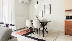 Un espace repas moderne comprenant une table, des chaises et un luminaire suspendu.