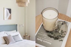A neatly made bed with pillows and a bedside table with a lamp.