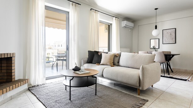 Un salon moderne avec un canapé, une table basse et une cheminée.