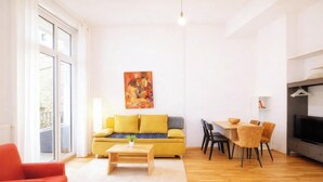Una sala moderna con sofá, mesa de centro y comedor.