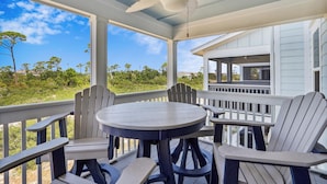 A covered outdoor seating area with a round table and chairs, a ceiling fan, and a view of the surrounding landscape. - Lost Key Golf & Beach Club Townhome -Make Waves ~  NO HASSLE CHECK OUT (Perdido Key)