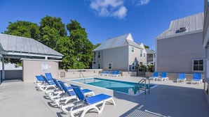 A pool area with lounge chairs and a pool.