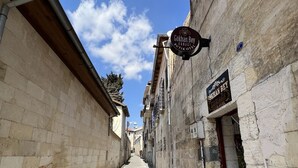 A narrow cobblestone street flanked by historic stone buildings with signs for "Gökhan Bey Konak Hotel." - Gökhan Bey Konağı  (Gaziantep)