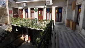 A courtyard with a covered seating area, air conditioning units, and a staircase leading to the upper floor. - Gökhan Bey Konağı  (Gaziantep)