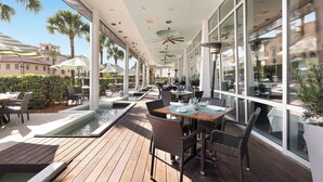 An outdoor dining area with tables and chairs, a pool, and large windows. - Seagrove Beach Home + Private Pool, & Bikes (Santa Rosa Beach)