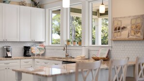A kitchen with white cabinets, a coffee maker, a sink, and a window with plants. - Seagrove Beach Home + Private Pool, & Bikes (Santa Rosa Beach)