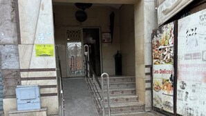 A building entrance with a tiled floor, metal handrails, and a staircase leading inside. - Family apartment 07 (Marrakech)