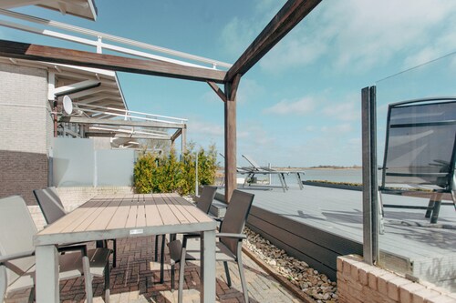 Luxurious Dijkvilla Deluxe with a panoramic view of the IJsselmeer, a private sauna, and two patios at the exclusive Beach Resort Makkum.