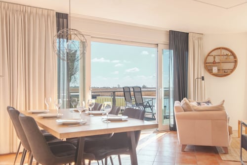 Detached fisherman's villa for 6 persons with a patio above the water, bathtub, and jetty at Beach Resort Makkum in Friesland.