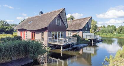 Detached 8-person fisherman's villa with a patio above the water and a private jetty at Beach Resort Makkum on the IJsselmeer.