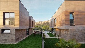 A modern building with a stone facade and a well-maintained lawn.